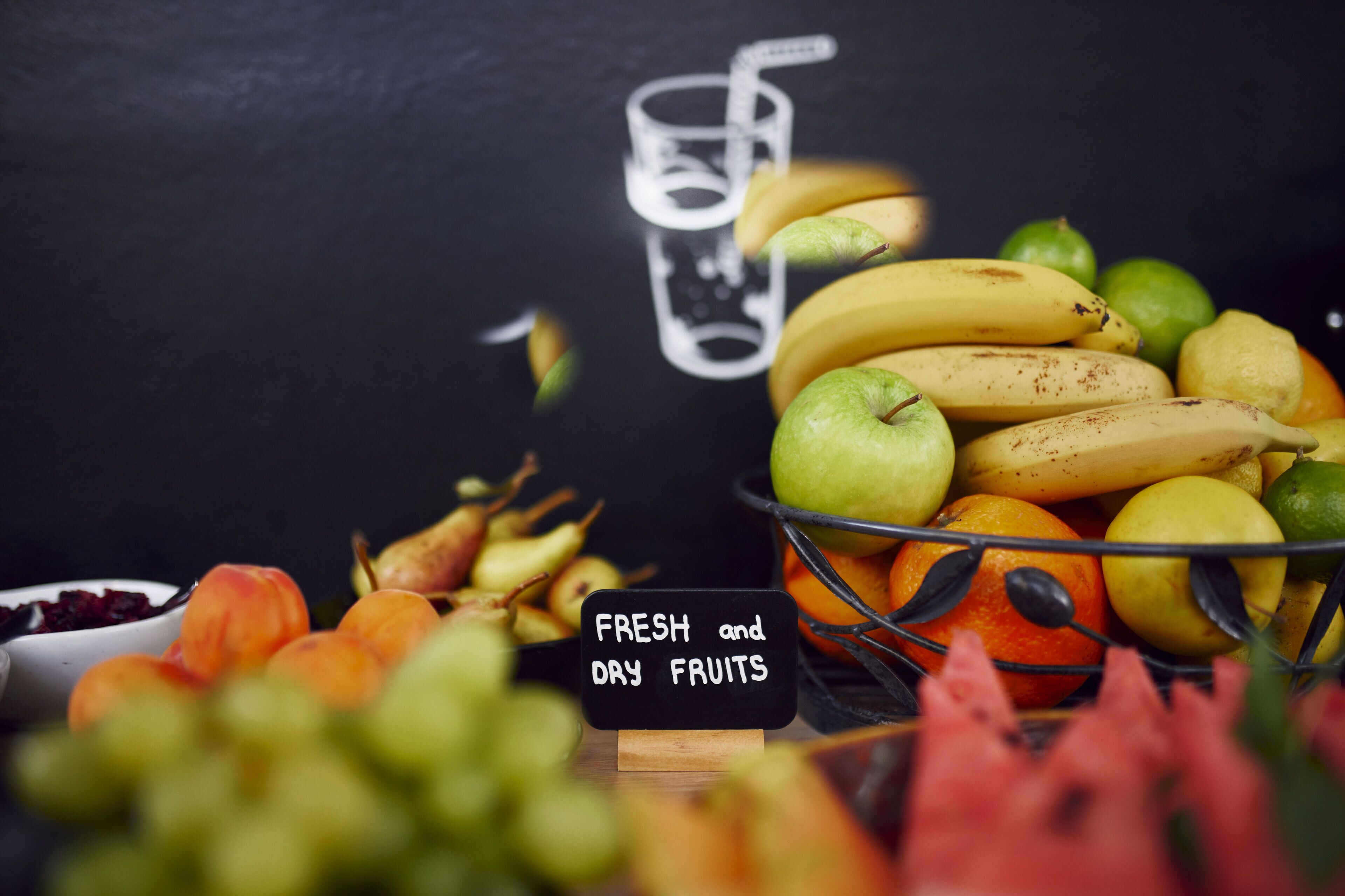 A variety of fresh and dry fruits displayed on a table with a sign indicating the types of fruits.