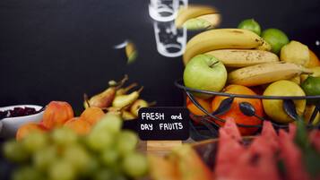 A variety of fresh and dry fruits displayed on a table with a sign indicating the types of fruits.