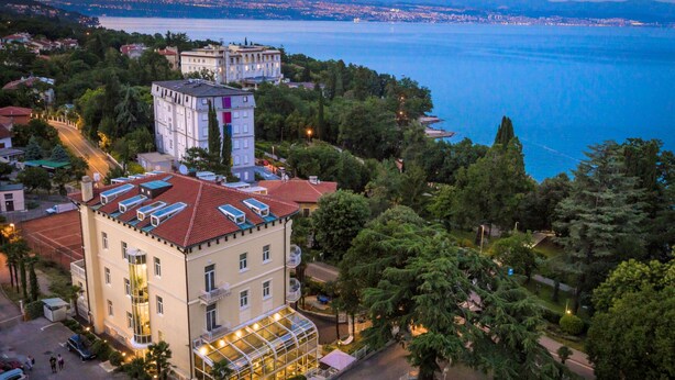 A hotel with a rooftop terrace, a central courtyard, and a view of a lake. - Hotel Villa Eugenia (Lovran)
