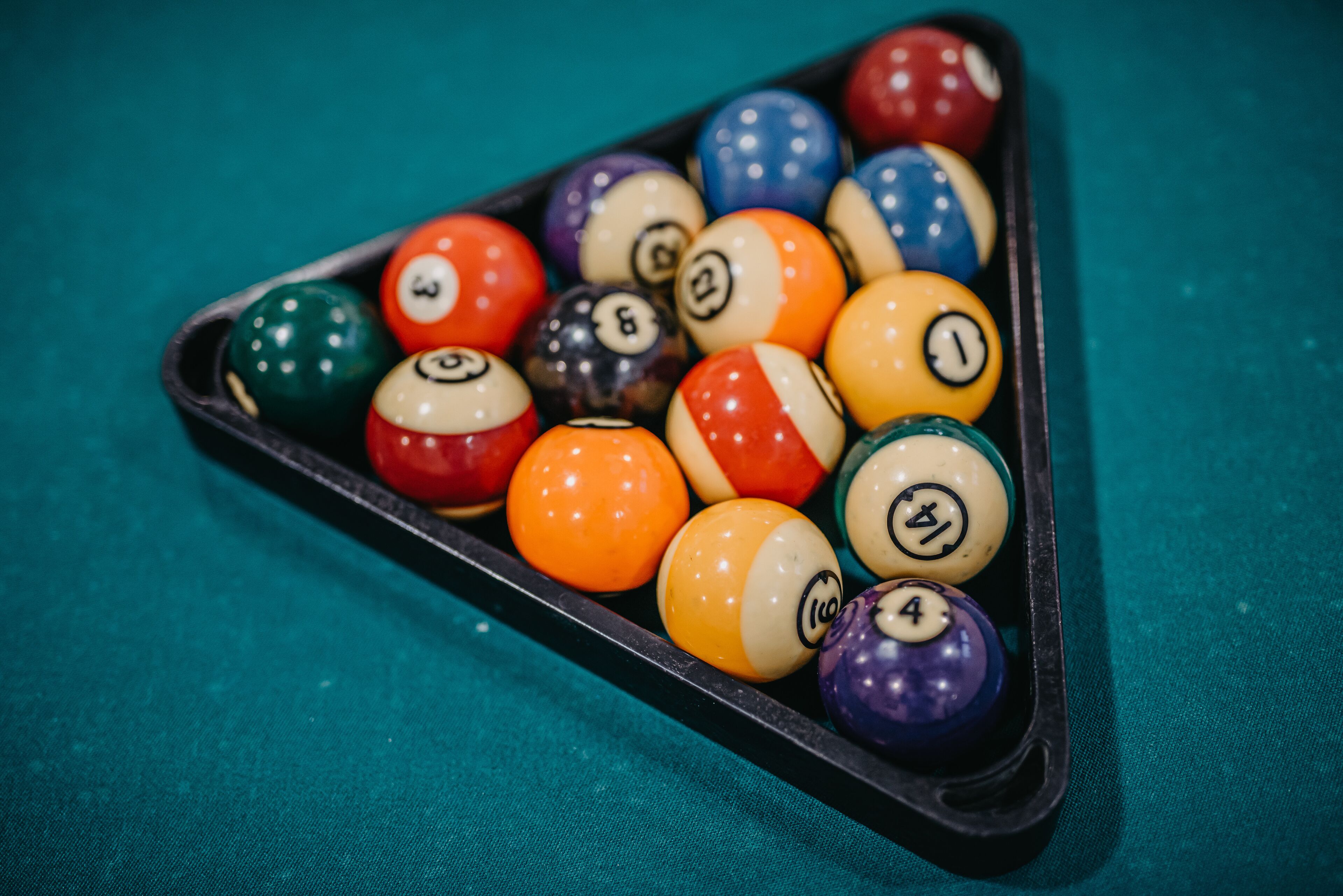 A pool table with a triangular rack filled with billiard balls.