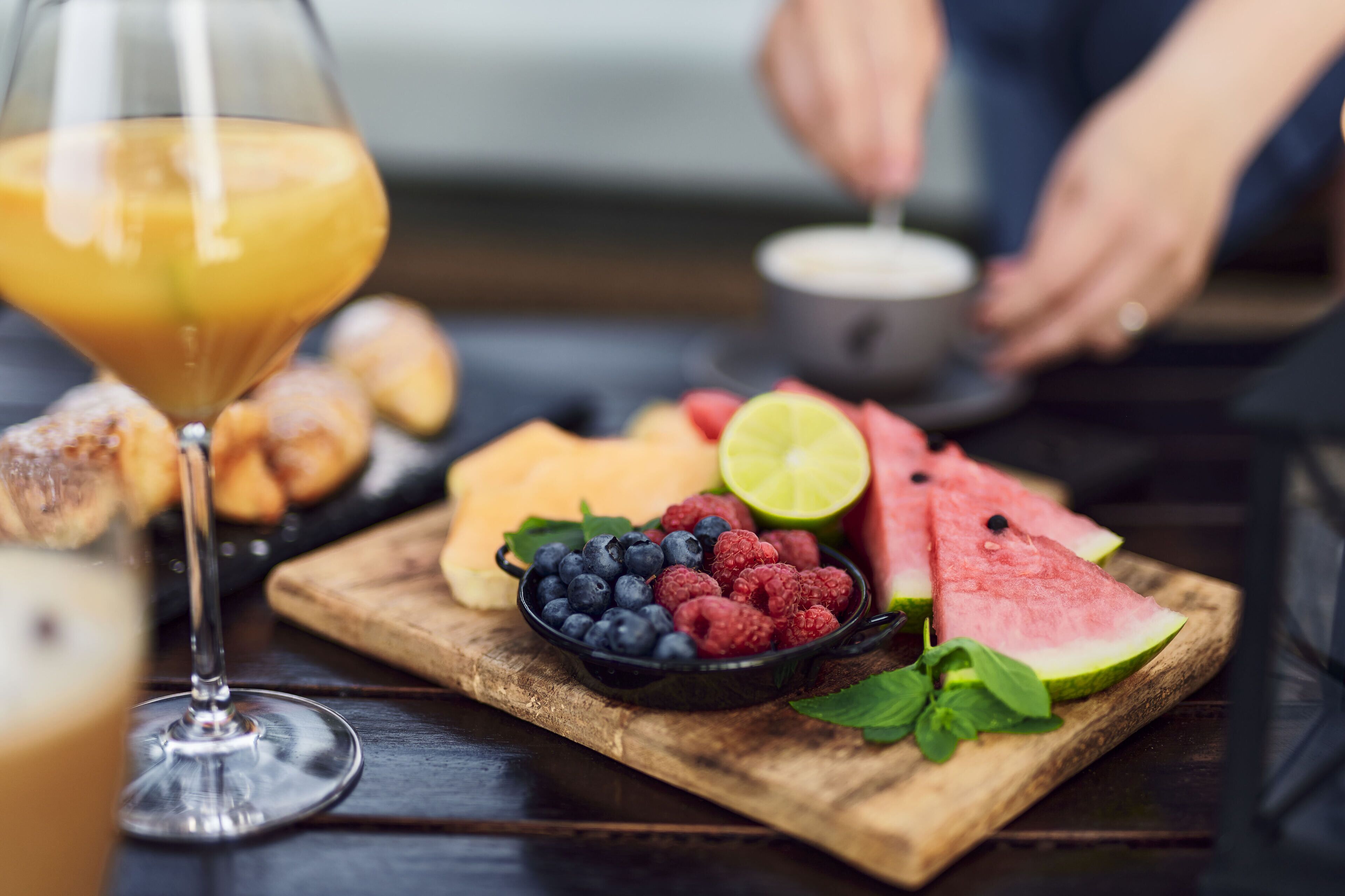 Ein Holzboden mit Früchten und einem Glas Orangensaft.