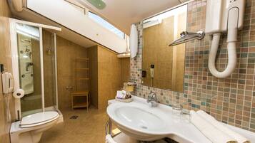 Un baño con ducha, inodoro, lavabo y espejo.