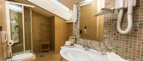 A bathroom with a shower, toilet, sink, and a mirror.