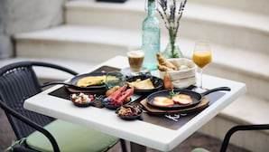 A breakfast tray with various foods and drinks on a table outside. - Hotel Villa Eugenia (Lovran)