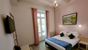 A hotel room with a bed, bedside tables, a TV, and a painting on the wall. - Will's Hotel (Narbonne)