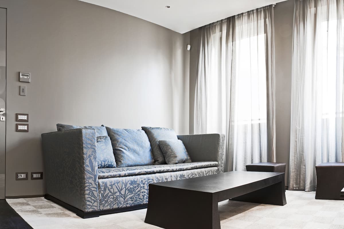 A modern living room with a sofa, a coffee table, and a lamp.