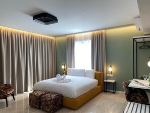 A modern hotel room with a large bed, a small table with two chairs, a mirror, and a window with curtains. - Oasi Village Hotel (Milan)