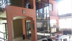 A multi-level interior with a dining area, a staircase, and a balcony with a view. - Hotel Boutique Aybal (Salta)