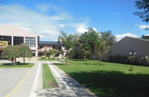 A building with a sign reading "BAL" and a well-maintained lawn with trees and a pathway. - Hotel Boutique Aybal (Salta)