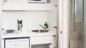 A compact kitchenette with a microwave, sink, and small refrigerator. - NOX HOTELS - Notting Hill (London)