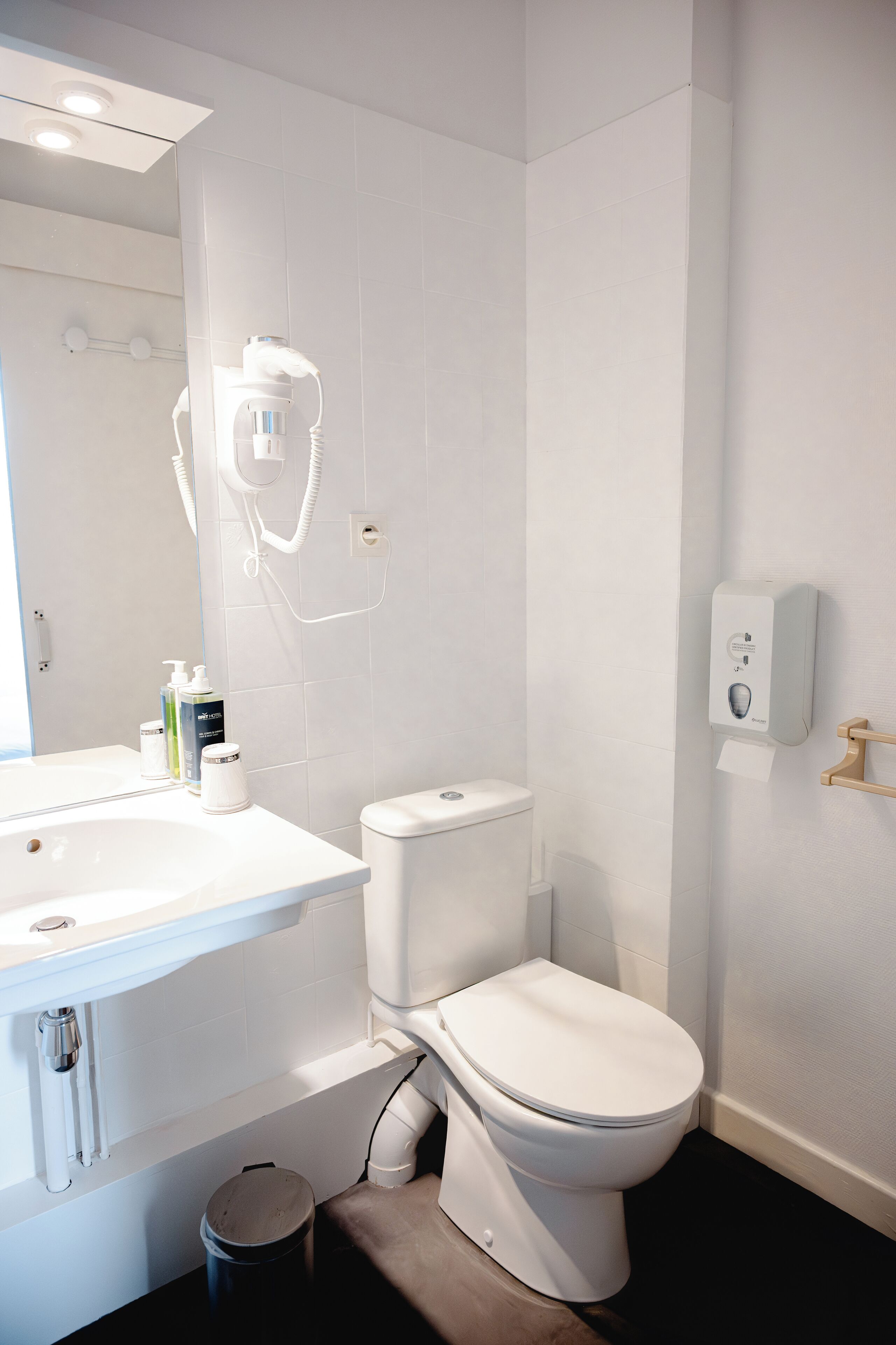 A modern bathroom with a white sink, toilet, and shower.