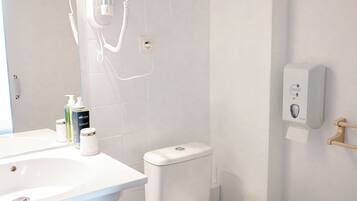A modern bathroom with a white sink, toilet, and shower.