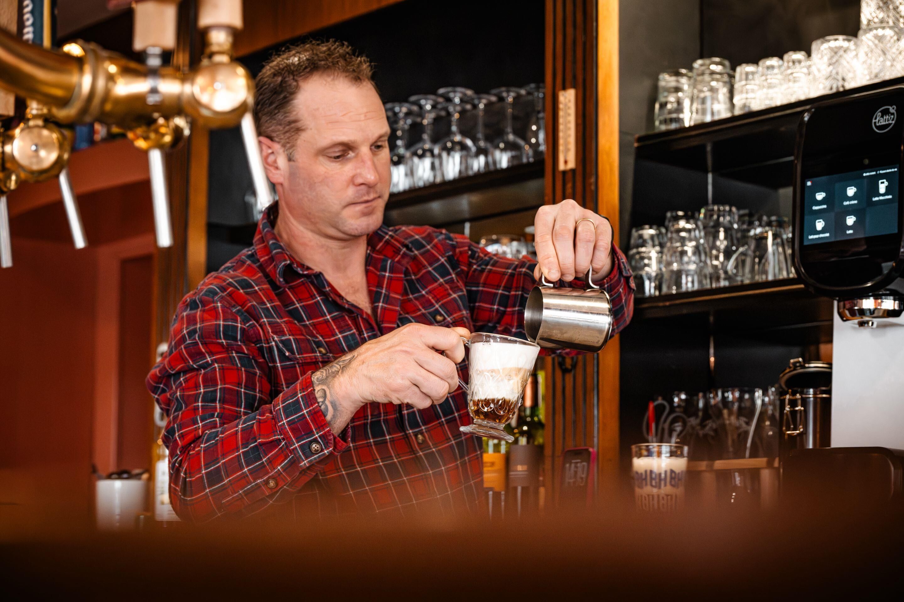 En person som häller upp en dryck från en kran i ett glas.