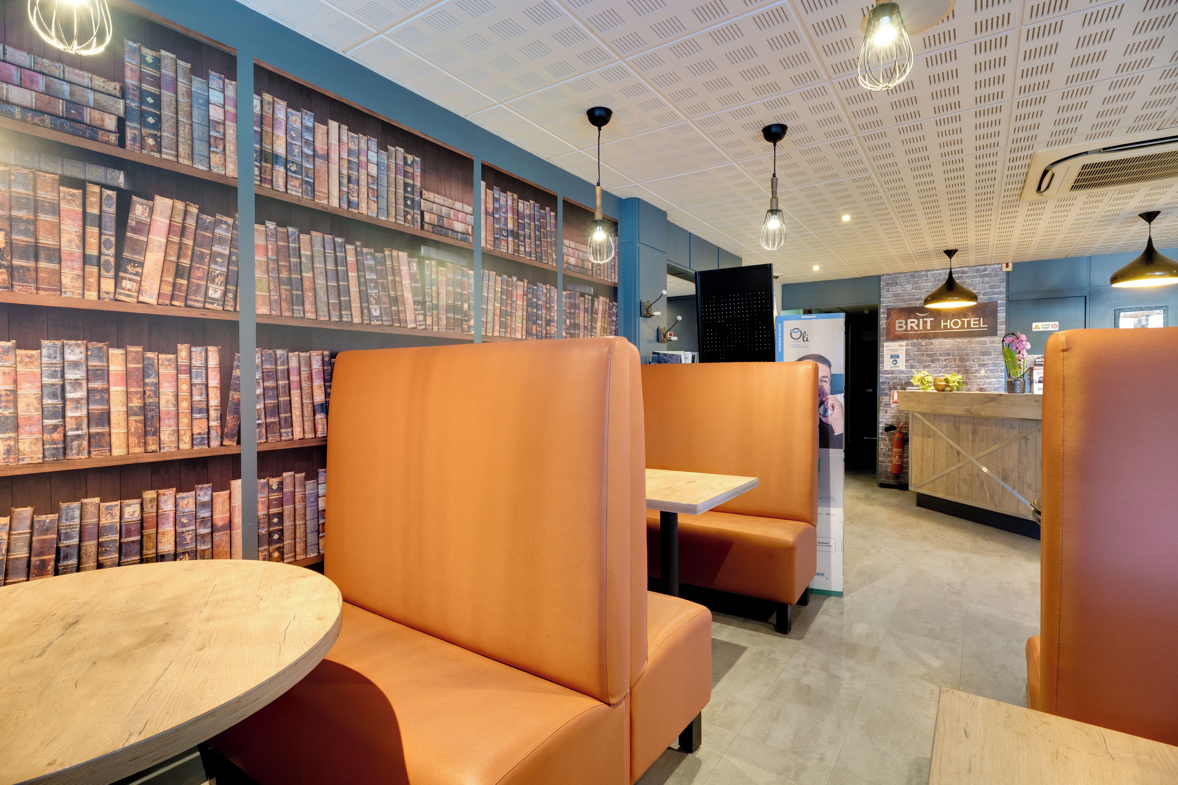 A library with bookshelves, seating areas, and a reception desk.