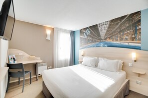 A hotel room with a bed, a desk, a chair, a television, and a large window. - Brit Hotel La Rochelle Périgny (Perigny)
