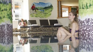 A pool area with lounge chairs and a mural of a landscape. - Sport Hotel Vittoria (Vermiglio)