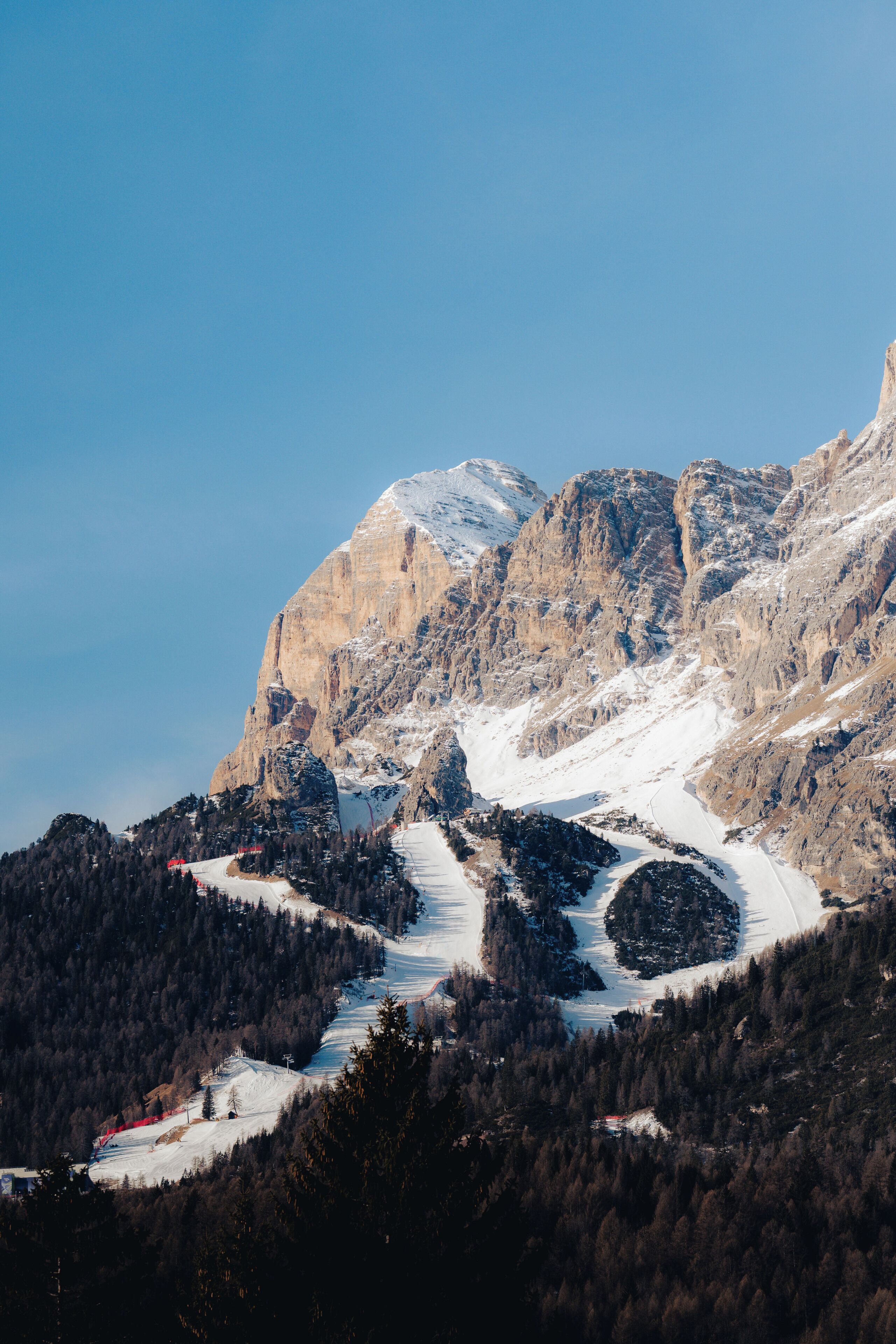A mountainous landscape with a snow-covered slope and a clear sky.
