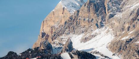 A mountainous landscape with a snow-covered slope and a clear sky.