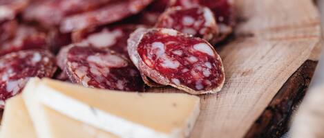 A wooden board with various types of cured meats and cheeses.