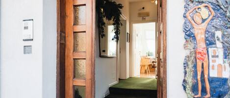 A wooden door leading to a staircase with a green carpet.