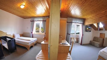 A cozy room with a wooden ceiling, a bed, a desk, and a sofa.