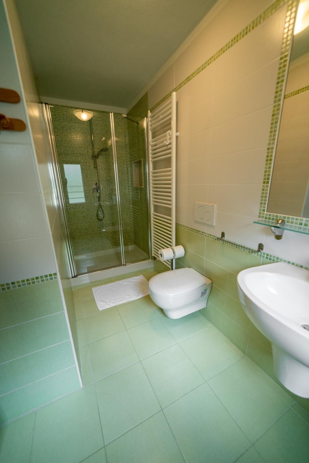 A bathroom with a shower, toilet, and sink.