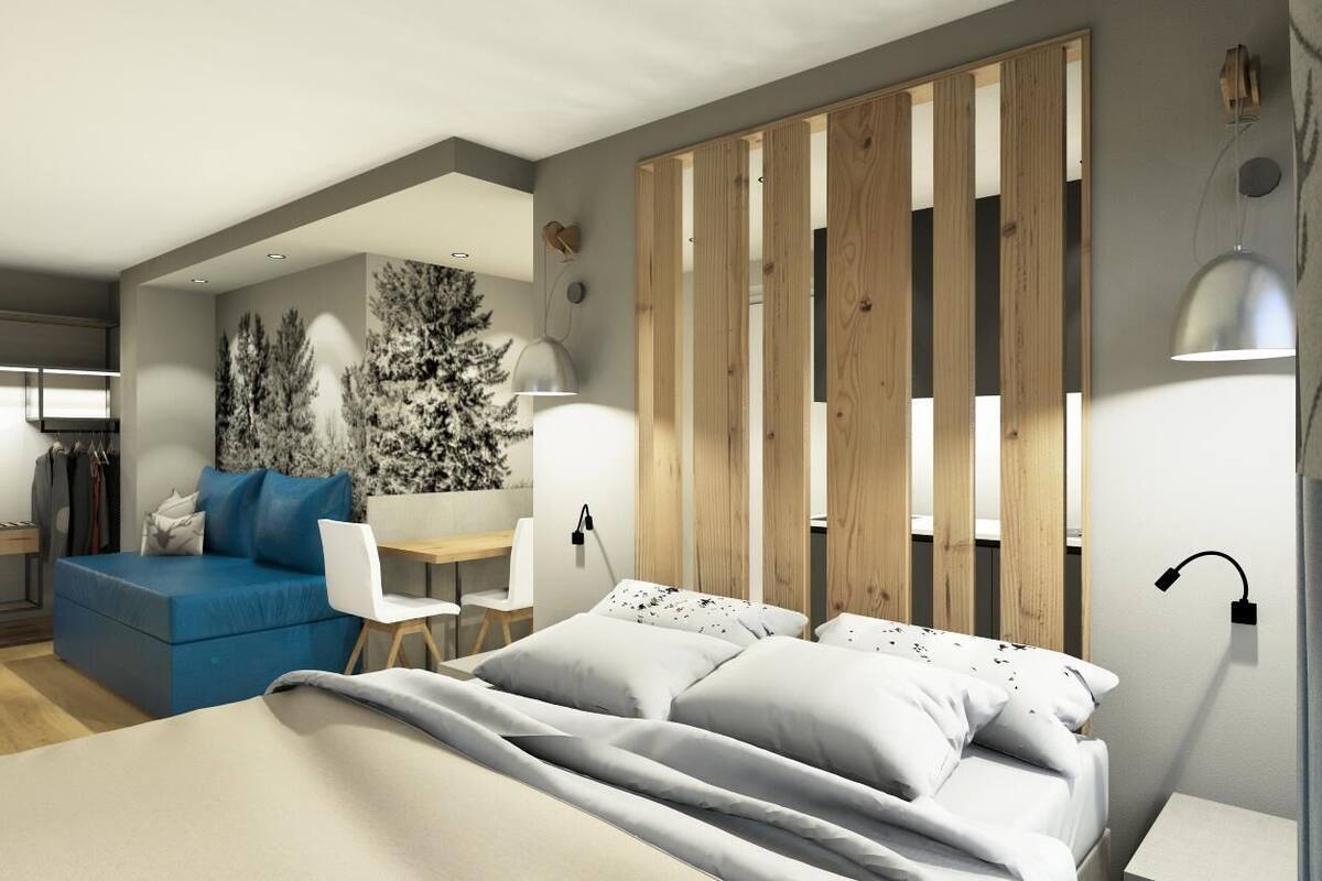 Un dormitorio moderno con una cama grande, un sofá azul, un escritorio y una lámpara de pared.