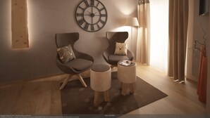 A modern living room with two armchairs, a round wall clock, a floor lamp, and a small table with magazines. - Al Sole Mountain Chic (Folgaria)