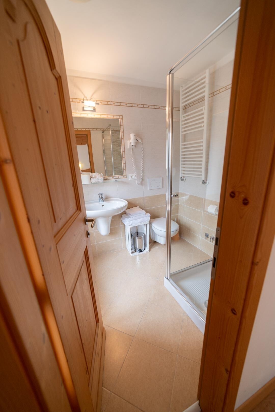 A modern bathroom with a glass shower enclosure, a sink, and a toilet.