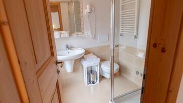 A modern bathroom with a glass shower enclosure, a sink, and a toilet.