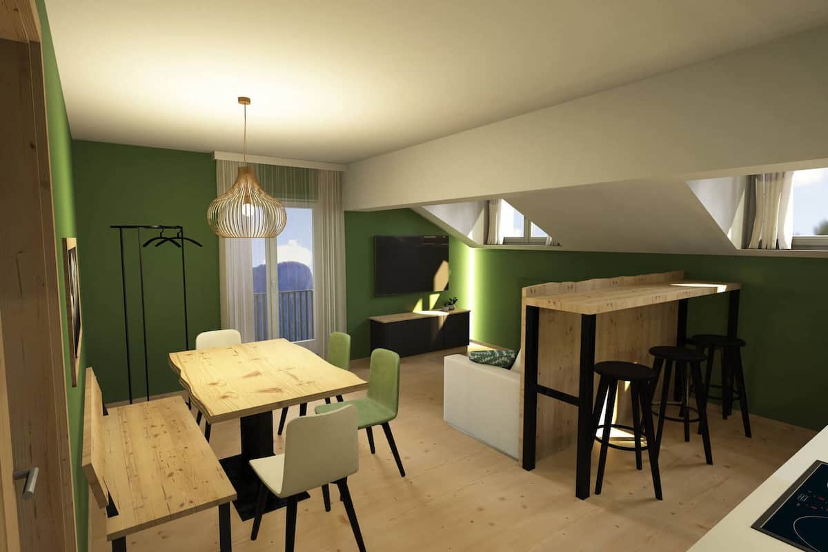 Una cocina moderna con encimeras de madera, un comedor con mesa y sillas de madera, una lámpara colgante y vistas al exterior a través de una ventana.
