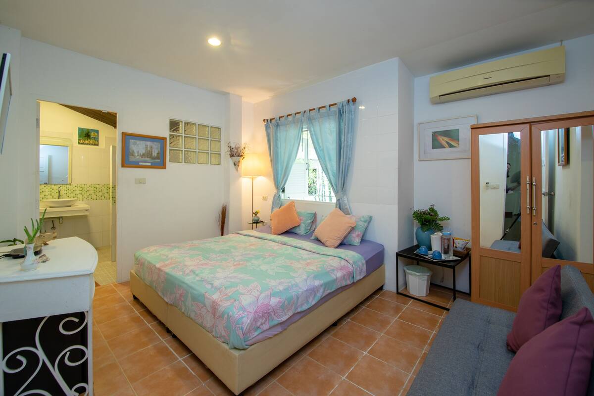 Un dormitorio con cama, mesita de noche, lámpara y armario.