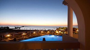 A resort pool with a view of the sea at dusk. - Georgioupolis Beach Hotel (Apokoronas)