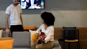 A living room with a sofa, a television, and a chair. - Ibis Belo Horizonte Savassi (Belo Horizonte)