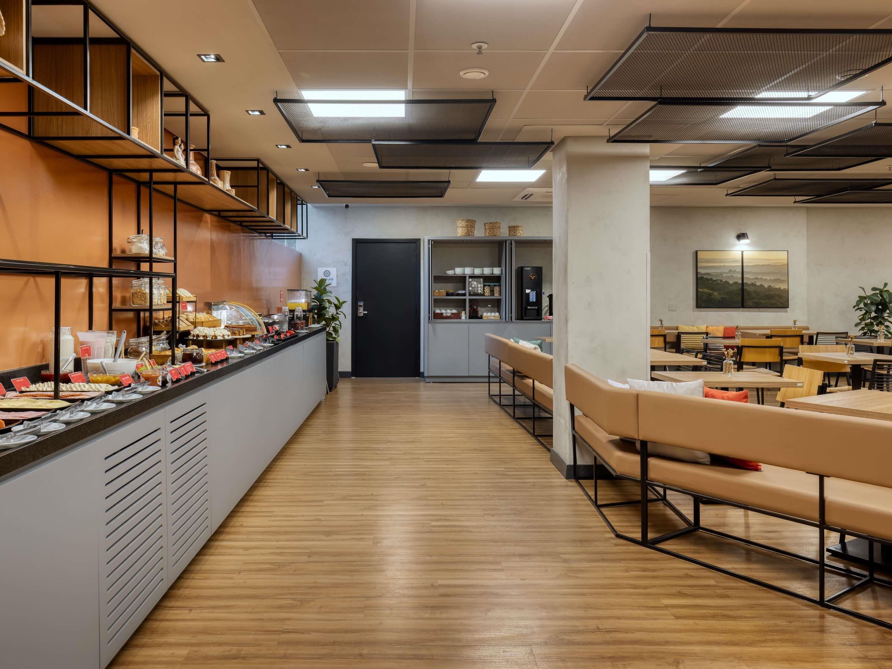 Un restaurant moderne doté d’un long comptoir, de planchers en bois et de différents espaces pour s’asseoir.