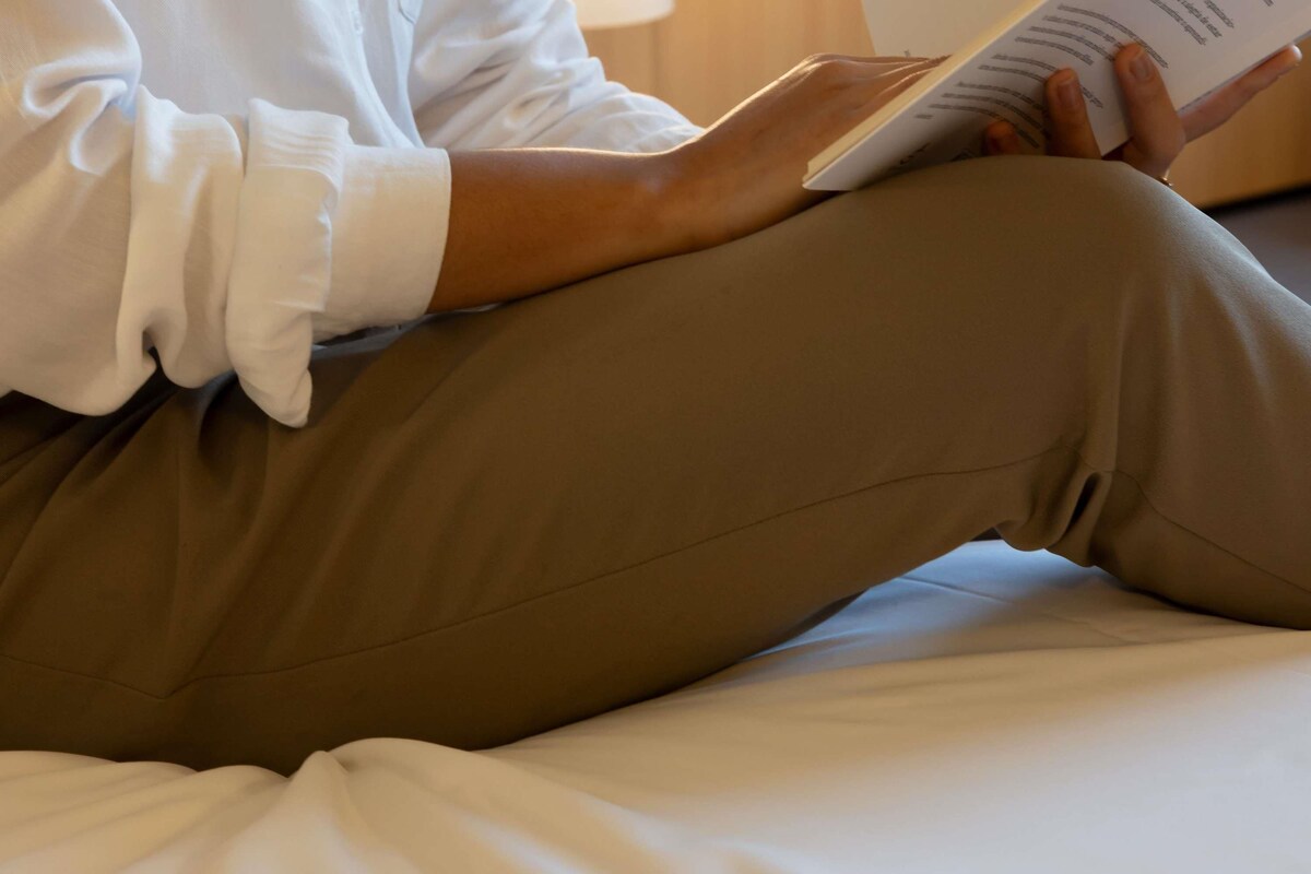 A person sitting on a bed with a book.