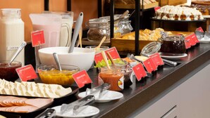 A buffet with various food items and condiments, including yogurt, cheese, and spreads. - Ibis Belo Horizonte Savassi (Belo Horizonte)