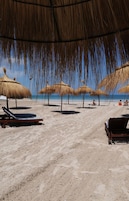 Arena blanca, tumbonas, sombrillas y toallas de playa