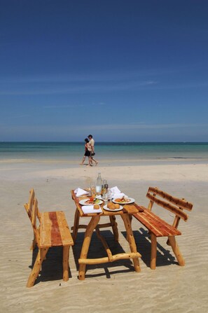 Areia branca, espreguiçadeiras, guarda-sóis, toalhas de praia 