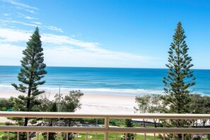 A balcony with a view of a beach and ocean.