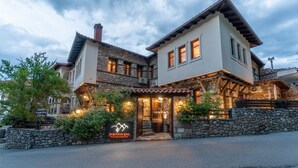 A two-story building with a stone facade, a wooden balcony, and a sign reading "The Canyon Lodge." - To Palio Litohoro (Dio-Olympos)