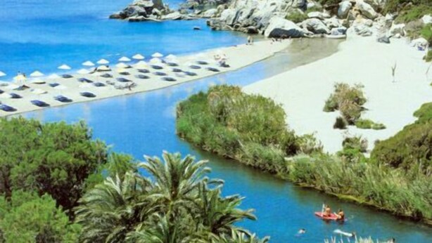 Una località balneare con piscina, ombrelloni da spiaggia e un fiume.
