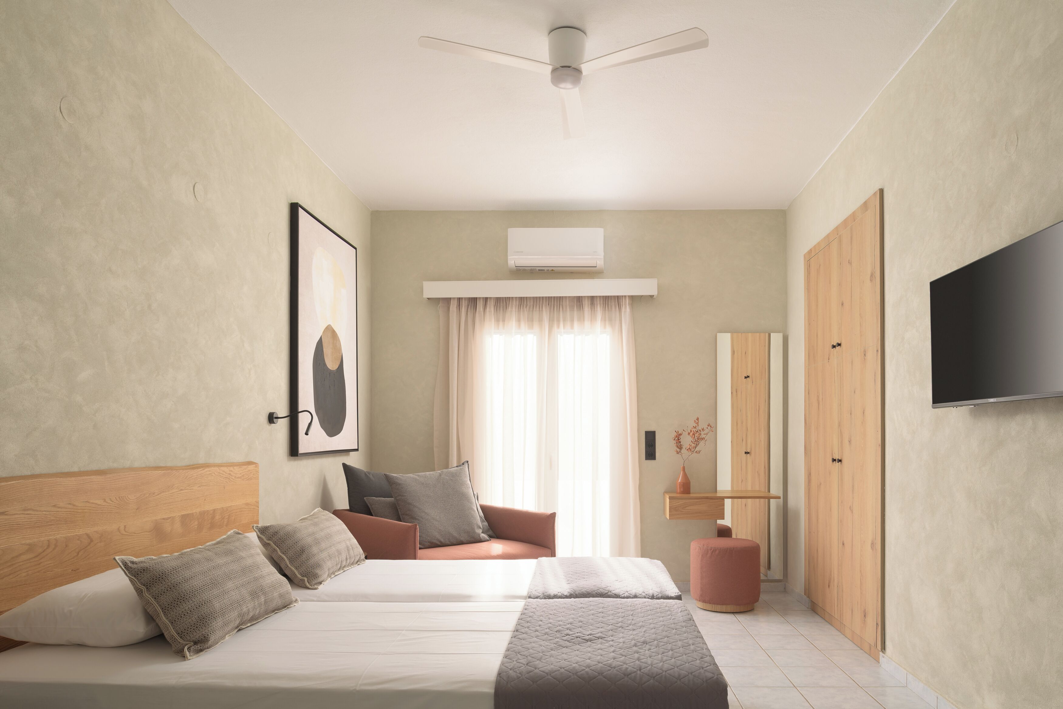 A modern bedroom with a bed, a ceiling fan, an air conditioning unit, a TV, and a wardrobe.
