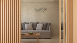 Un soggiorno moderno con un divano, un tavolino da caffè e un elemento decorativo a parete.