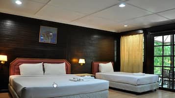 A hotel room with two beds, dark wooden walls, a painting, and a window with curtains.