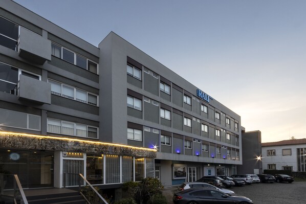 A multi-story hotel with a modern design, featuring a prominent 'R' logo on the facade. - Hotel Rali Viana (Viana do Castelo)