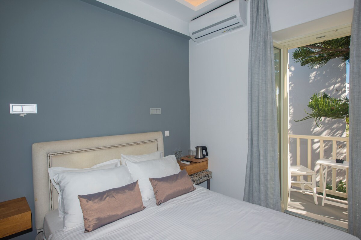 A bedroom with a bed, bedside table, and an air conditioning unit.