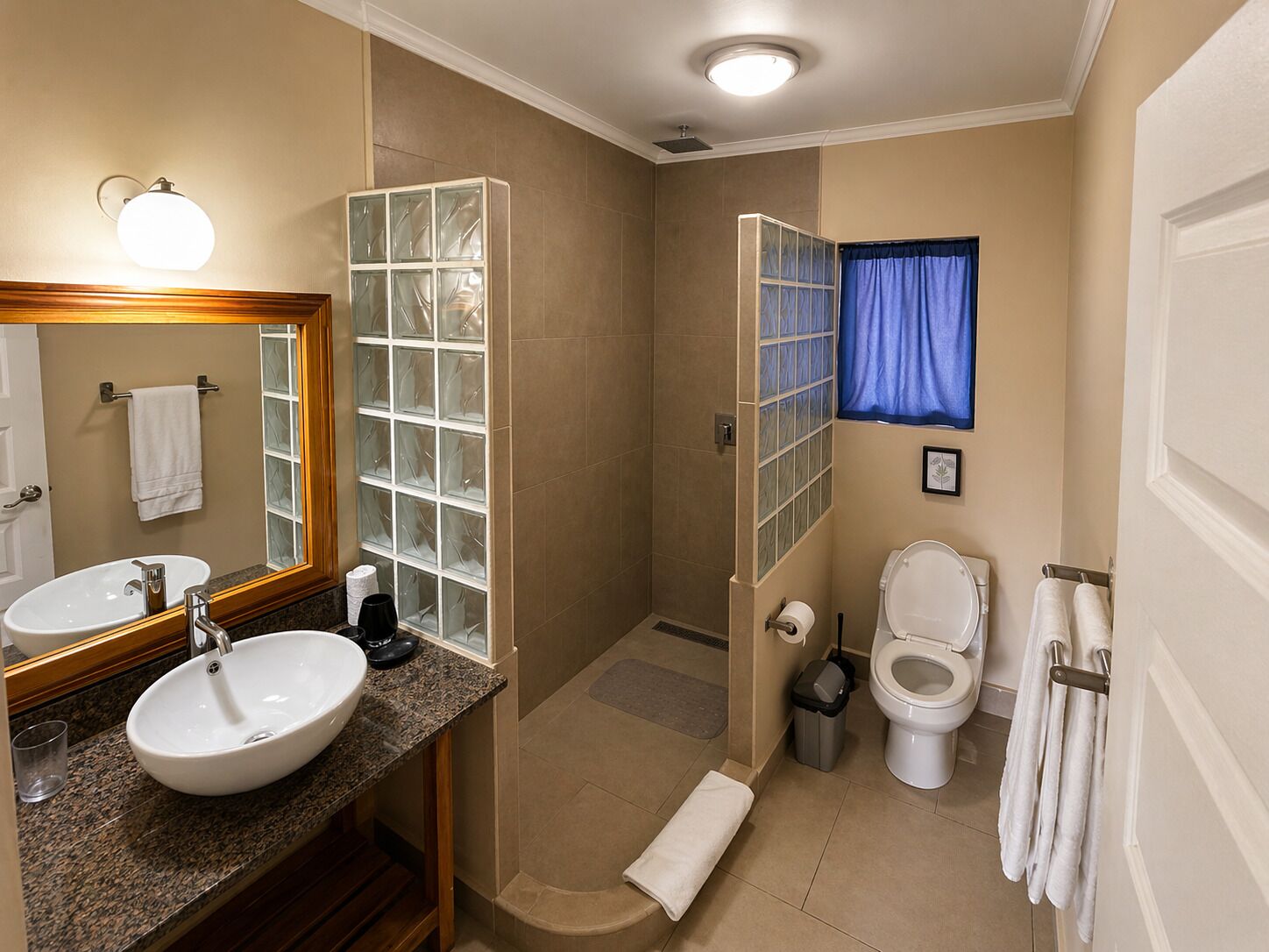 A bathroom with a sink, mirror, toilet, and shower.