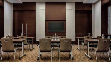 A conference room with a large table, six chairs, and a screen at the front.