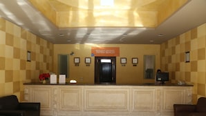 A reception area with a checkered wall pattern, a reception desk, and two leather chairs. - Tamra Beach Resort (Sharm El Sheikh)